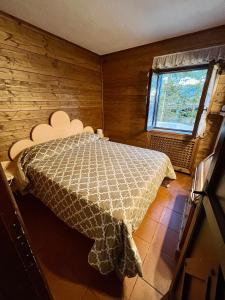 um quarto com uma cama num quarto com uma janela em Chalet dei Conti em Pescocostanzo