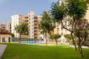 a park with trees and buildings in the background at Estudio con piscina in Cala del Moral