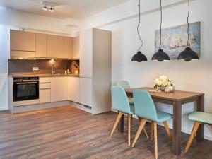 a kitchen and dining room with a wooden table and chairs at Ohlerich Speicher App_ 04 in Wismar