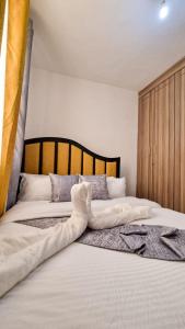 1 dormitorio con 2 camas con sábanas blancas en Spacious 1 bedroom with Parking Nakuru, en Nakuru