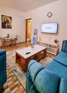a living room with a blue couch and a table at Spacious 1 bedroom with Parking Nakuru in Nakuru