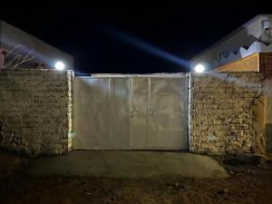 um portão numa parede de tijolos à noite em Haven Hideaway - The Summer Moon House em Dahab