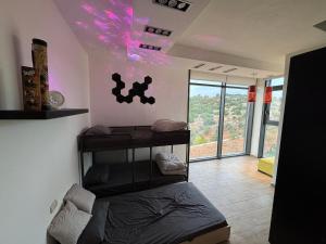 ein Schlafzimmer mit einem Bett in einem Zimmer mit lila Lichtern in der Unterkunft Shams Farm in Adschlun