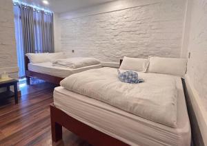 博卡拉的住宿－Dhikidada Resort，墙上的房间里设有两张床