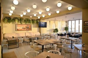 a restaurant with tables and chairs and a flat screen tv at Hotel Zanzi in Durrës