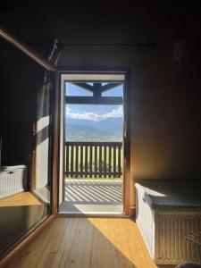 a room with a window with a view of a balcony at La montagnette in Embrun