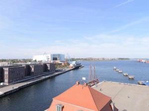Blick auf einen Fluss mit einem Gebäude und einem Dock in der Unterkunft Ohlerich Speicher App. 39 in Wismar