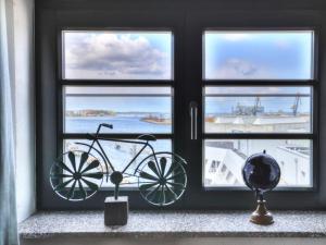 a bike in a window with a view of the ocean at Ohlerich Speicher App_ 40 in Wismar