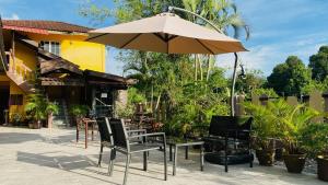 einen Tisch und Stühle mit Sonnenschirm auf einer Terrasse in der Unterkunft Motel Seri Mutiara in Kuah