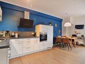 ヴィスマールにあるOhlerich Speicher App_ 32の青い壁のキッチン(白いキャビネット付)