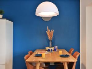 ヴィスマールにあるOhlerich Speicher App_ 32の青い壁のダイニングルーム(木製テーブル付)