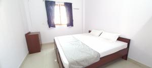 バラナシにあるMahadev Home Stayのベッドルーム1室(白いシーツ付きのベッド1台、窓付)