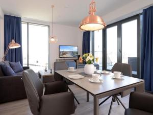 een woonkamer met een tafel en stoelen en een bank bij Ohlerich Speicher App_ 46 in Wismar