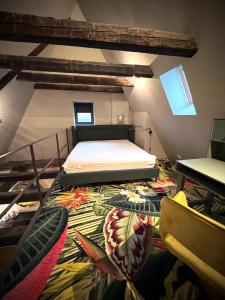 a bedroom with a bed and a rug on the floor at Pebbles Suiten by RiNG in Regensburg
