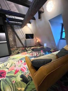 een woonkamer met een bank en een tv bij Pebbles Suiten by RiNG in Regensburg
