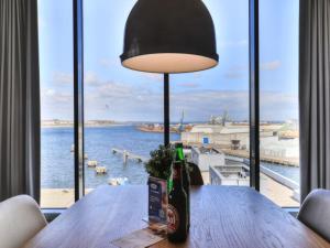 - une bouteille de bière assise sur une table en bois avec une fenêtre dans l'établissement Ohlerich Speicher App_ 45, à Wismar