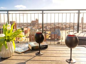 dwa kieliszki wina siedzące na stole na balkonie w obiekcie Ohlerich Speicher App 48 w mieście Wismar
