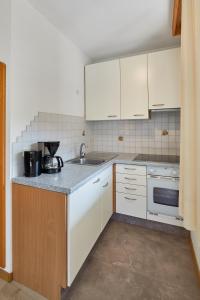 Una cocina con gabinetes blancos y un fregadero. en Mareiter Stein Blasighof, en Racines 23 fotos más