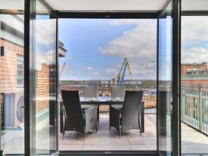 a balcony with a table and chairs and a view at Ohlerich Speicher App 43 in Wismar