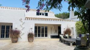 聖克萊蒙的住宿－Holiday Home Casa MADORIA，白色的房子,有两张长椅和一张桌子