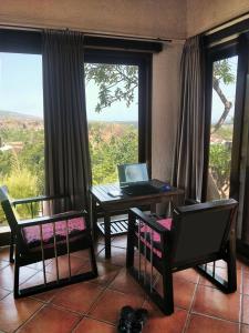 ein Wohnzimmer mit einem Tisch und einem Laptop darauf in der Unterkunft The Dharma Araminth Villa - Lovina Mountain and Sea View in Lovina