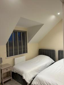 a bedroom with two beds and a window at No 1 The Paddock in Bude