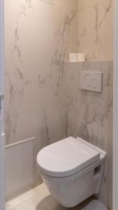 パリにあるApartment Saint Germain des Près by Studio prestigeの大理石の壁のバスルーム(白いトイレ付)