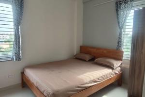 ein Bett in einem Schlafzimmer mit zwei Fenstern in der Unterkunft Compact yet beautiful 1bhk 001 in Bangalore