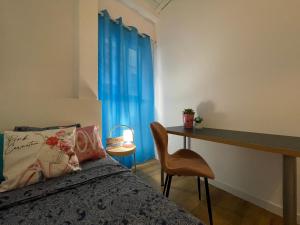 a bedroom with a bed and a desk and blue curtains at Rooms in Gothic in Barcelona