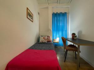 Habitación pequeña con cama roja y escritorio. en Rooms in Gothic, en Barcelona