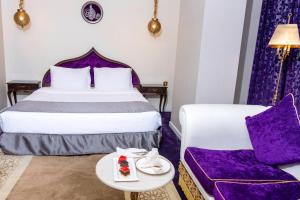 Habitación de hotel con cama y sofá en Saraya Corniche Hotel en Doha