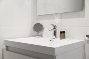 La salle de bains est pourvue d'un lavabo blanc et d'un miroir. dans l'établissement Le Saint Louis, à Amiens