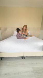 a woman and a child sitting on a bed at The Queen Airport Hotel in Arnavutköy