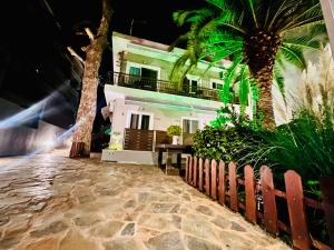 una casa en la playa por la noche con palmeras en Phoenix Garden Apartment I, en Atenas