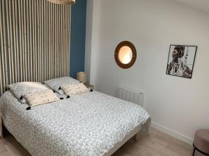 a bedroom with a bed and a mirror on the wall at Petite maison de charme à 10 minutes de Disney ! in Montévrain
