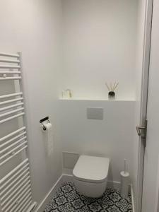 a small white bathroom with a toilet in it at Petite maison de charme à 10 minutes de Disney ! in Montévrain