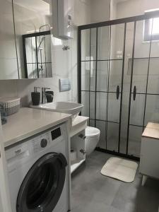 a white bathroom with a washing machine and a sink at Camelia 2 Beautiful 1+1 on Cleopatra in Alanya