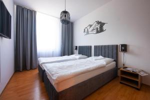 a bedroom with two beds and a large window at Hotel Spolcentrum in Jezersko