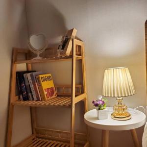 a small table with a lamp and a book shelf at Hue Stay in Ansan