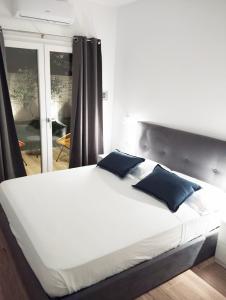 a bedroom with a large white bed with blue pillows at Le pergole in Olbia