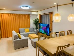 a living room with a table and a dining room at Kamei House in Tokyo