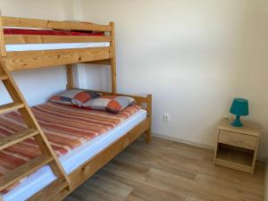 ヤロスワビエツにあるSofia Dwupoziomowe Apartamentyのベッドルーム1室(二段ベッド2台、ランプ付きテーブル付)