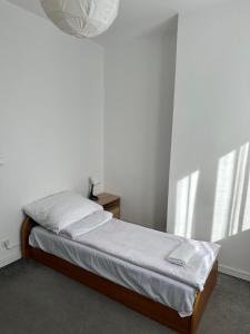 a bedroom with a bed with white sheets and a window at Hostel Demi in Krakow