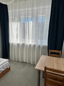 a room with a table and a window with curtains at Hostel Demi in Krakow