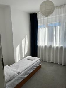 a bedroom with a bed and a large window at Hostel Demi in Krakow