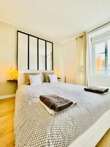 1 dormitorio blanco con 1 cama grande y 2 toallas en Sweetness Hyper Centre Ville, en Reims