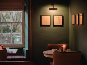 Coln Saint Aldwyn的住宿－力推考林新酒店，一间带桌子和窗户的用餐室