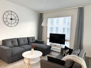 a living room with a couch and a tv at Hostit Arctic Apartments By BookLapland in Rovaniemi