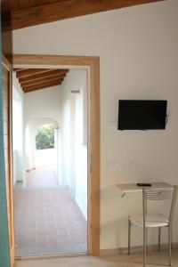 a room with a table and a television on a wall at Mediterraneo in San Teodoro