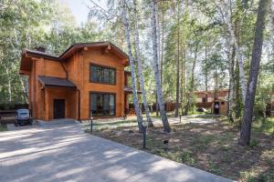 a house in the woods with a driveway at Villa - ваш загородный дом in Borovoye